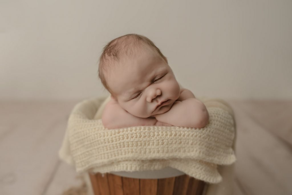 Baby Boy sleeping on his arms posed in a bucket - Best Newborn Photographer Vancouver