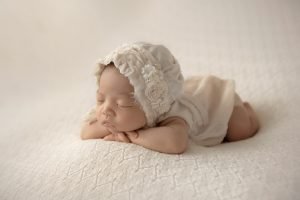 Newborn Photo Shoot Vancouver - Side view of a baby girl sleeping on her tummy resting her head on her hands
