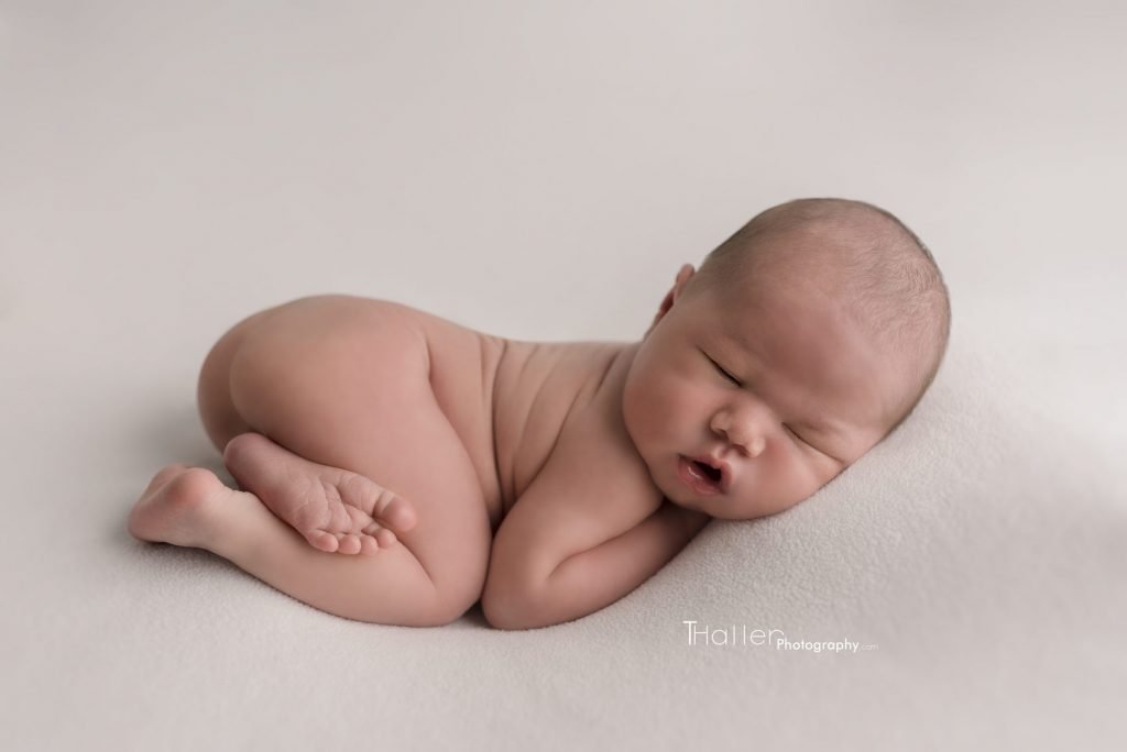 newborn boy sleeping in his belly