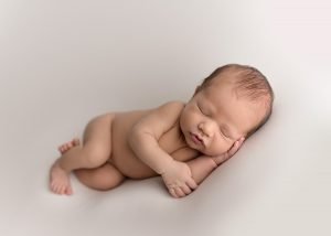 Newborn baby boy sleeping on his side