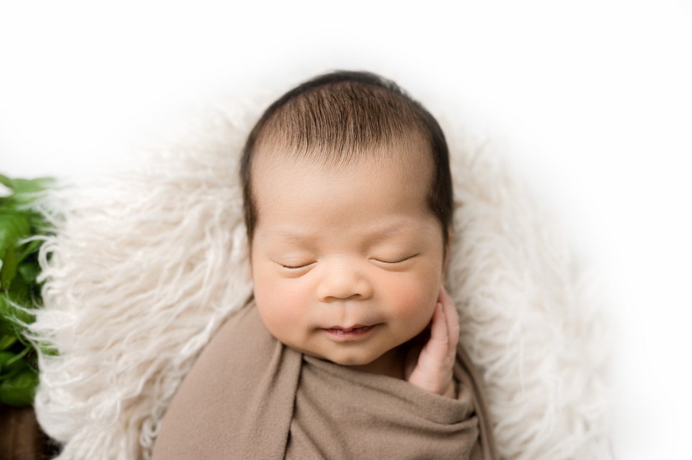 Newborn Photography Vancouver baby smiling holding his cheek