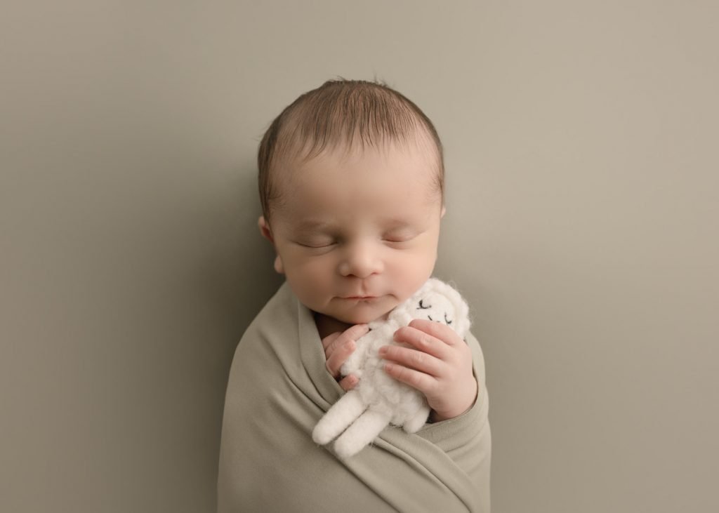 Burnaby Newborn Photography - baby boy holding a sheep smiling